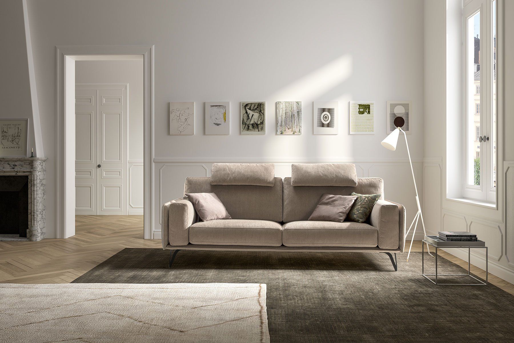 Luminoso soggiorno moderno con divano beige, quadri alle pareti e luce naturale proveniente dalla finestra.