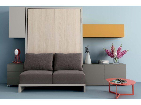 Soggiorno moderno con divano grigio, pannello in legno, mensole colorate e tavolino da caffè color corallo.