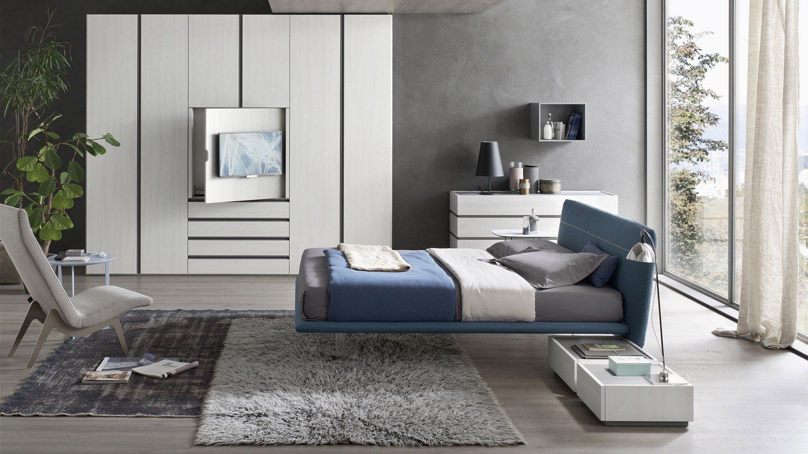 Camera da letto moderna con letto blu, tappeto grigio, armadio bianco e grandi finestre con tende.