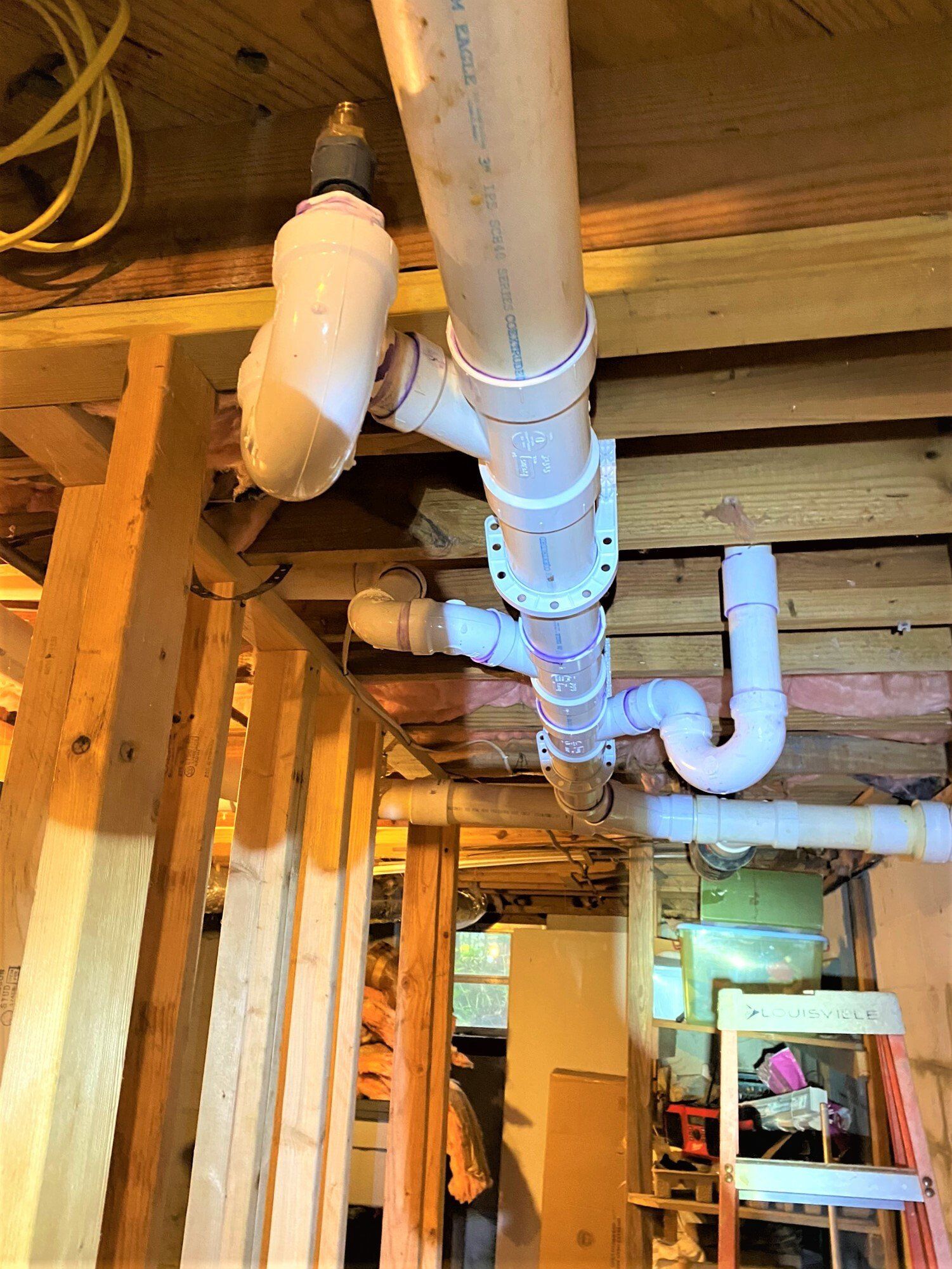 A bunch of pipes are hanging from the ceiling of a building.