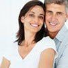 A man and a woman are posing for a picture together and smiling.