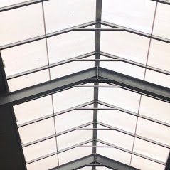 Een laag perspectief van een modern glazen dakraam met een symmetrische stalen frameconstructie.
