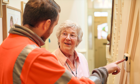 electrician guiding an elderly how to use the CCTV