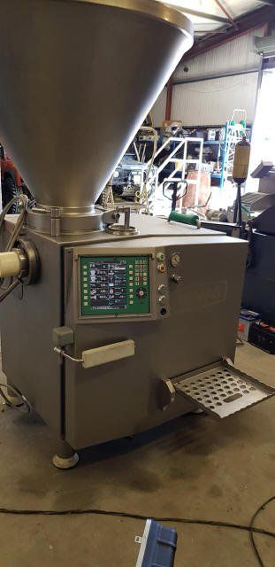 Large, stainless steel sausage stuffer machine. Controls on front panel, tray extended. Workshop setting.