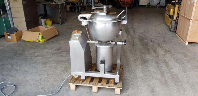 Stainless steel industrial mixer on a wooden pallet in a warehouse.