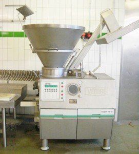 Industrial meat filling machine in a kitchen, stainless steel and gray, with a large funnel.