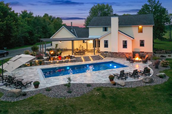 Rectangular inground pool with LED lighting and bubblers lit at dusk