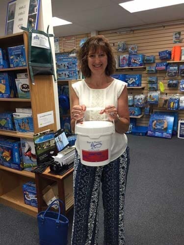 Lady holding a Tub of Chlorine — Pool Maintenance in Simsbury, CT
