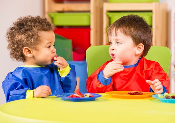 Two toddlers eating fruit in a nursery — Child Care in Victorville, CA