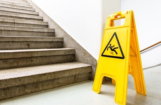 Yellow caution slippery surface sign next to concrete stairs. Yellow caution slippery surface sign next to concrete stairs.