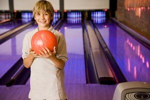 Boy Holding Bowling Ball — Bowling Center in Colorado Springs, CO Boy Holding Bowling Ball — Bowling Center in Colorado Springs, CO