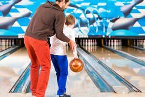 Boy Learning Bowling — Bowling Center in Colorado Springs, CO Boy Learning Bowling — Bowling Center in Colorado Springs, CO
