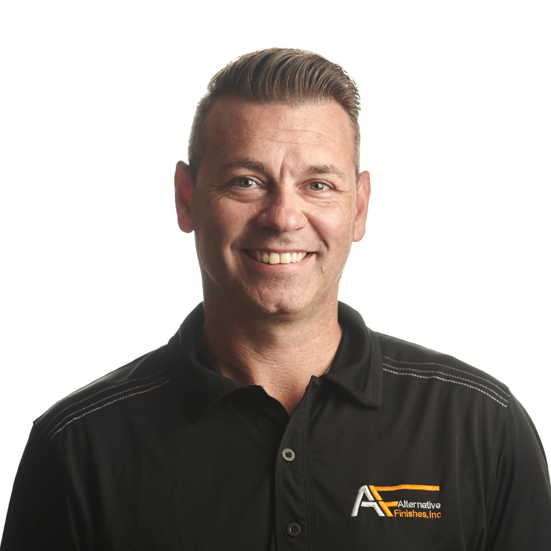 Man with short hair smiles at the camera, wearing a black polo shirt.
