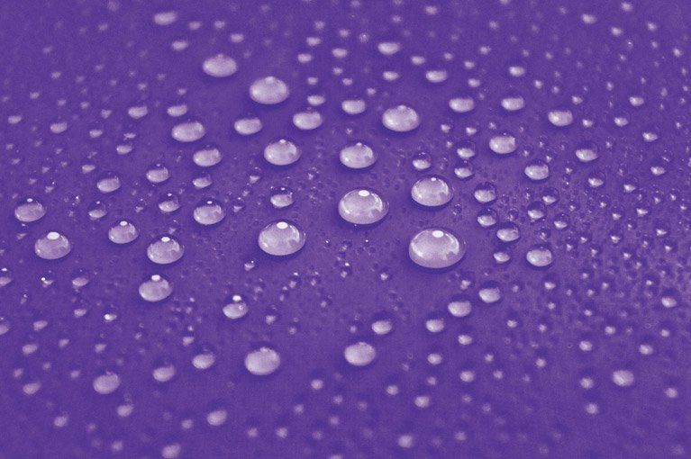 Water droplets on a purple surface protected by Xpel ceramic coating