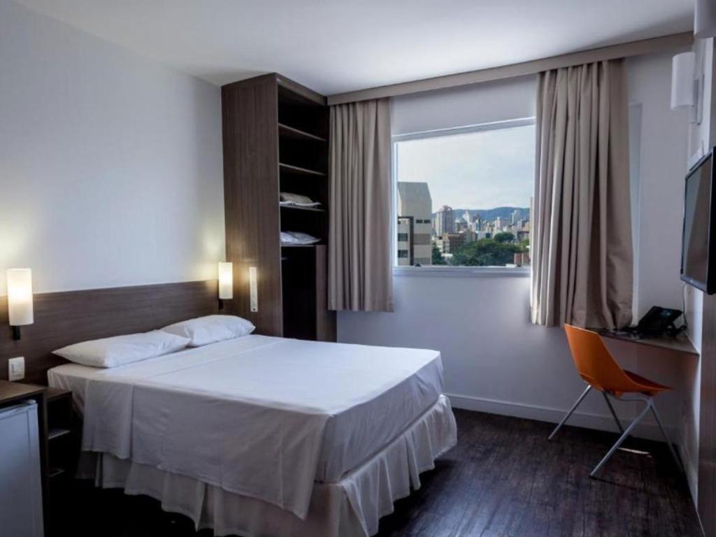 Um quarto de hotel com uma cama grande e uma janela