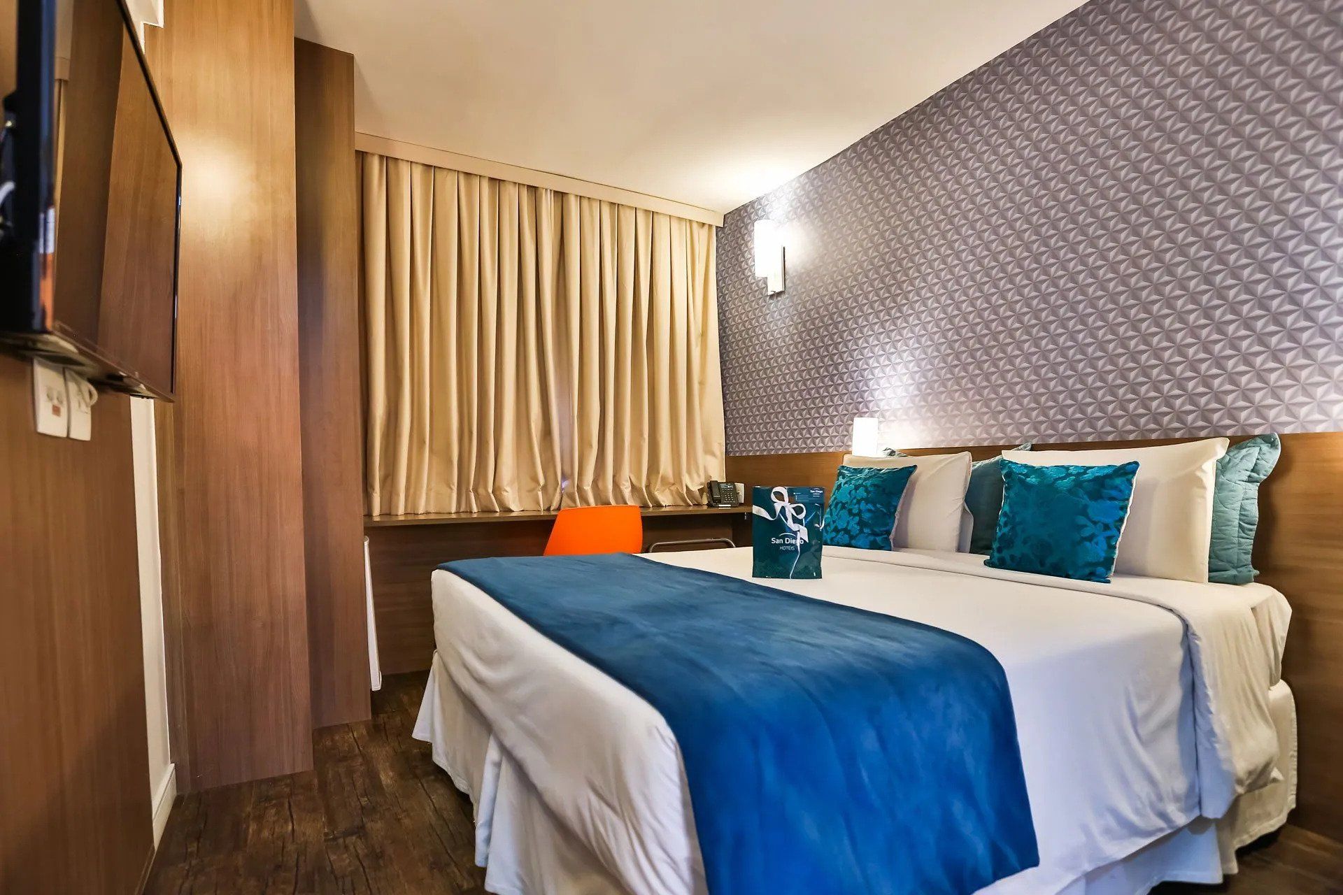 Um quarto de hotel com uma cama king size e uma televisão.