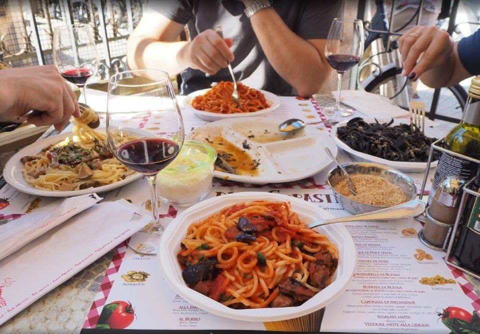 Guests at the table with fresh pasta dishes