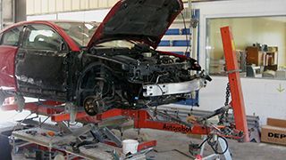 red car up on a lift needing repairs Greensboro, NC