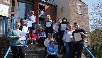 Peoples are out side the building  with certificates