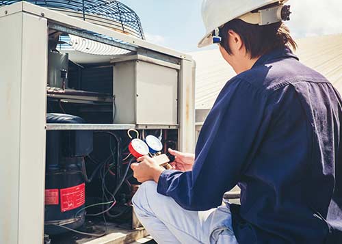 Residential Heating Repair — Repairman Checking Air Conditioner in Pittsfield, MA Residential Heating Repair — Repairman Checking Air Conditioner in Pittsfield, MA