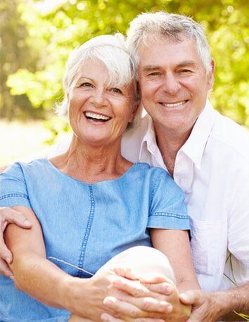 Senior couple sitting on grass together — General Dentistry in Tallahassee, FL Senior couple sitting on grass together — General Dentistry in Tallahassee, FL