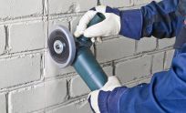 Construction worker uses a concrete grinder in South Auckland