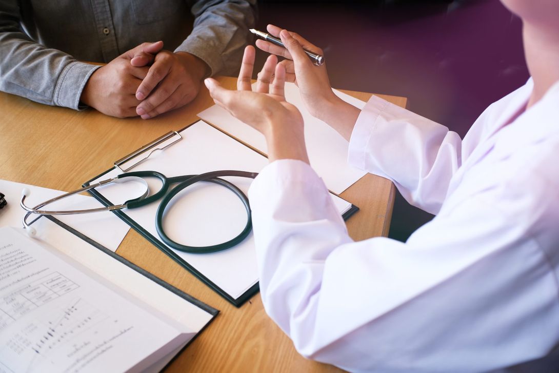 medico legale seduto alla scrivania con un suo cliente