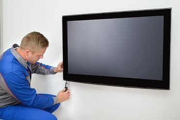 TV repair technician servicing flat-screen