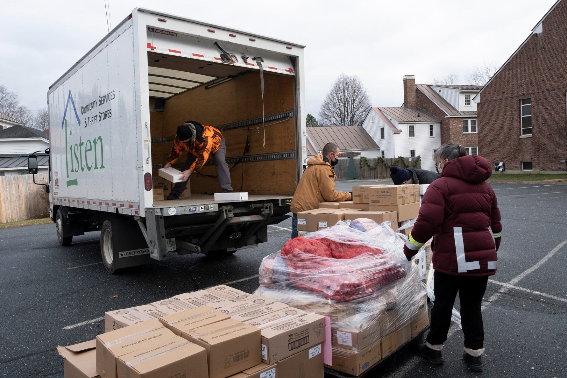 A man is unloading boxes from the back of a truck.