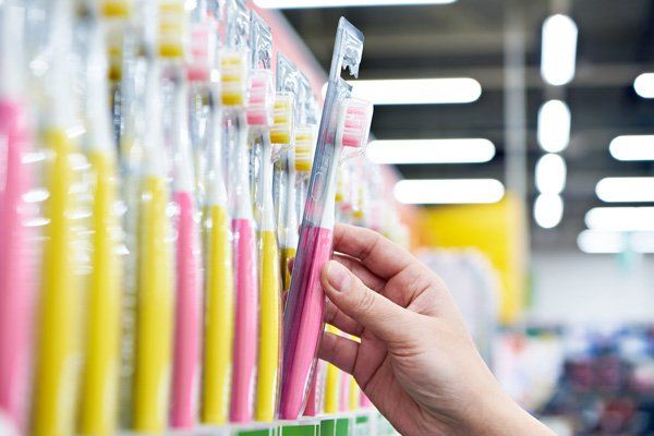 A person is holding a toothbrush in a store.