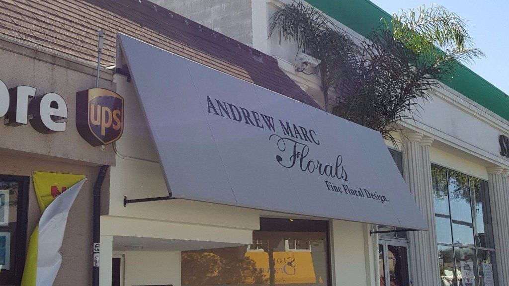 Storefront with a white awning reading “Anderson’s Florist” beside a UPS sign.