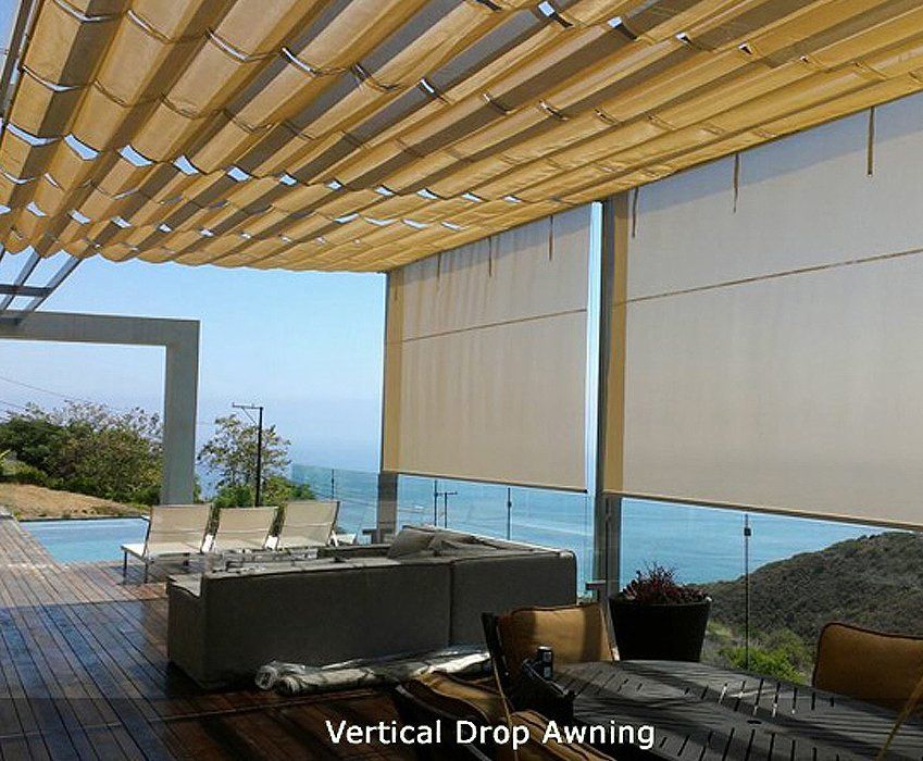 Patio with vertical drop awning, bamboo roof, lounge chairs, and ocean view