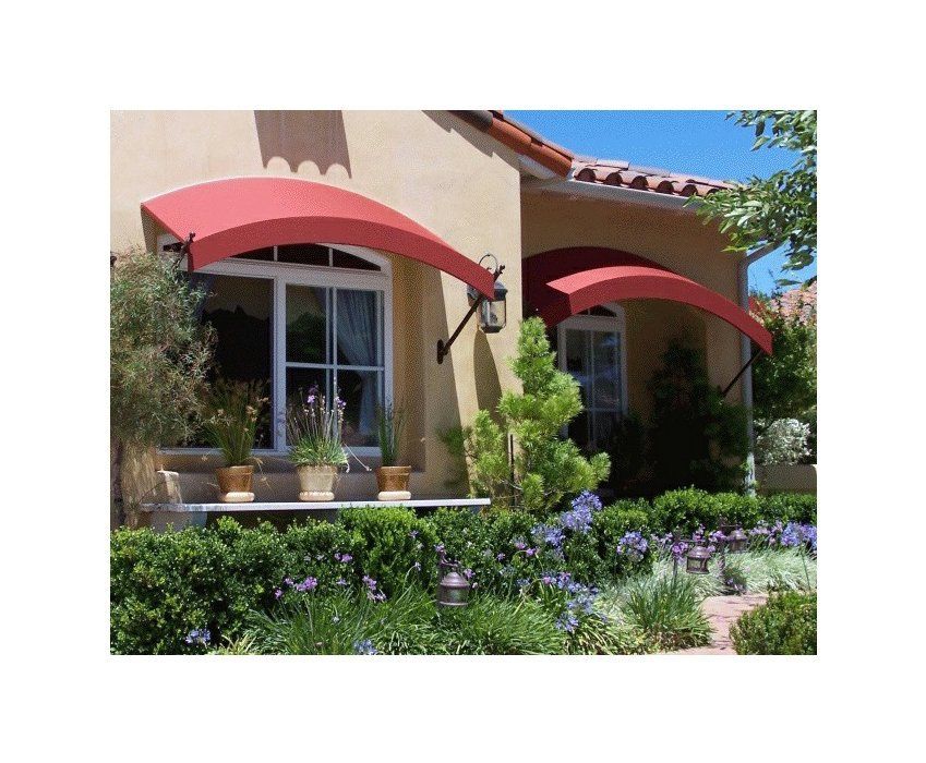Mediterranean-style house with red awnings, potted plants, and purple flowers in the front garden