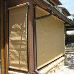 Beige roll-down outdoor blinds covering a patio or porch opening