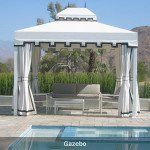 White gazebo with curtains and a sofa beside a pool on a sunny day