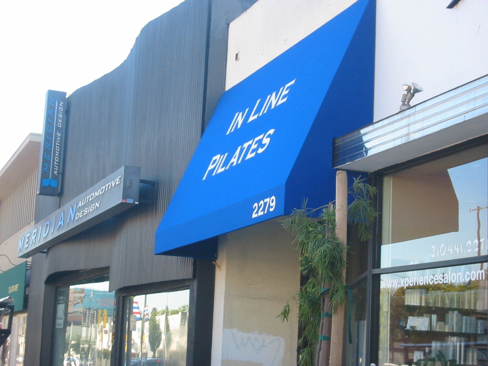 Blue awning over a storefront reading “Mr. Lime Pilates” on a city street