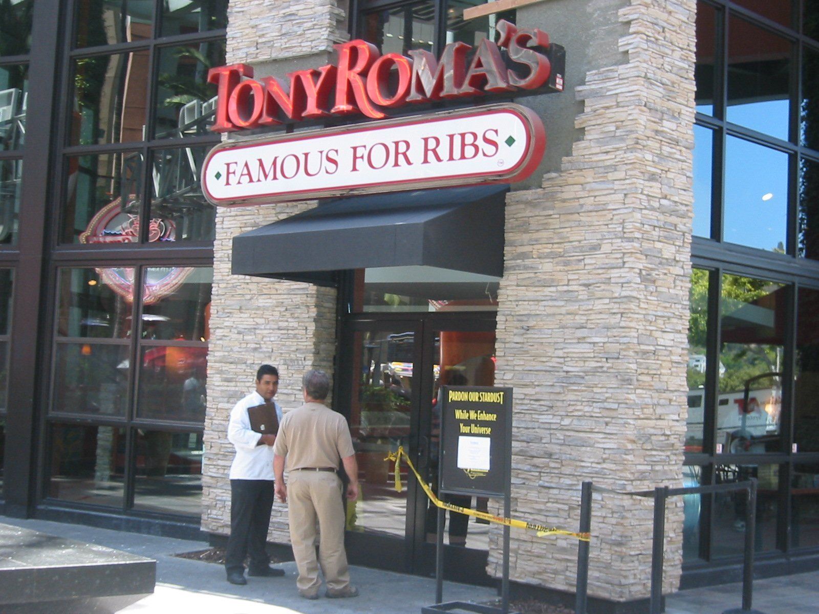 Tony Roma’s restaurant entrance with two people standing outside near the doorway