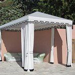 White canopy gazebo tent with draped curtains in a patio courtyard
