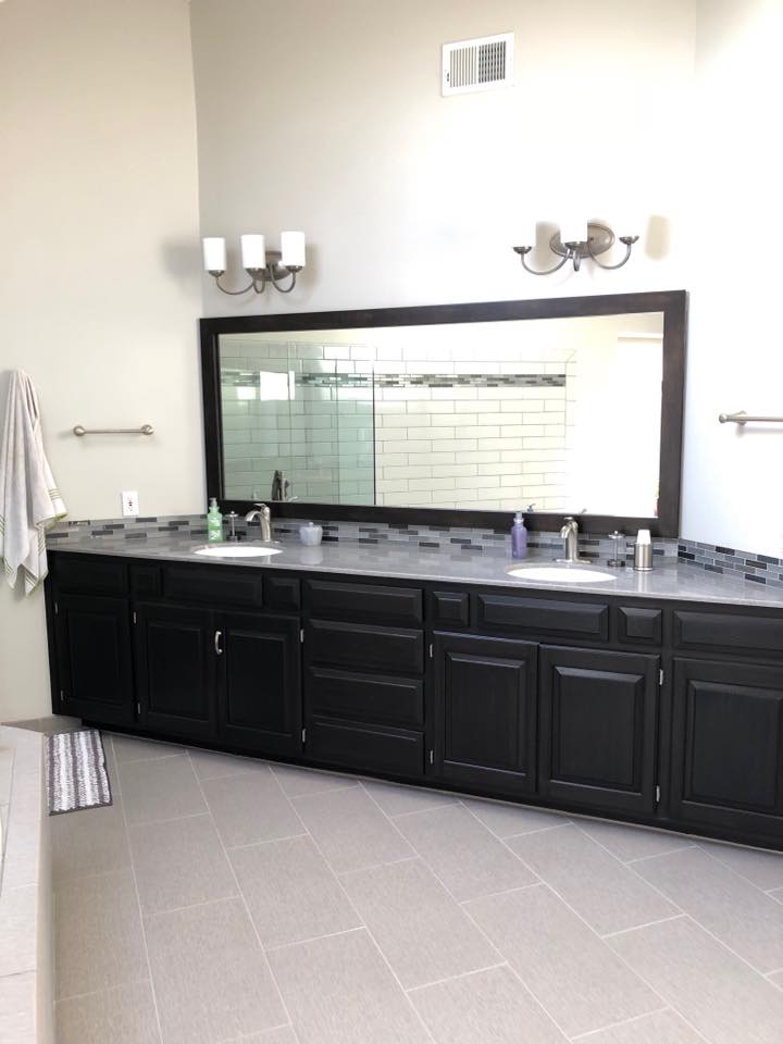 A bathroom with two sinks and a large mirror