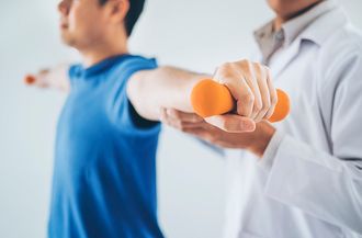 Physiotherapist Giving Exercise With Dumbbell Treatment — Moulton, AL — Plaxco Chiropractic Clinic Physiotherapist Giving Exercise With Dumbbell Treatment — Moulton, AL — Plaxco Chiropractic Clinic