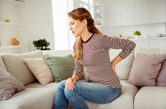 Beautiful Woman Suffering From Back Pain — Moulton, AL — Plaxco Chiropractic Clinic