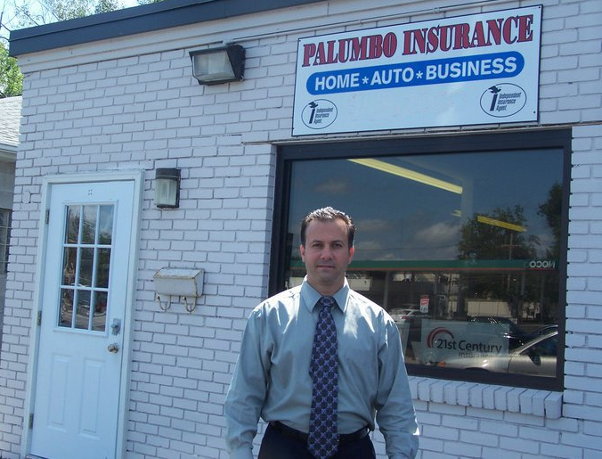 a man standing in front of a building that says palumbo insurance