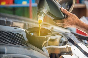 Man Pouring Oil Into Car