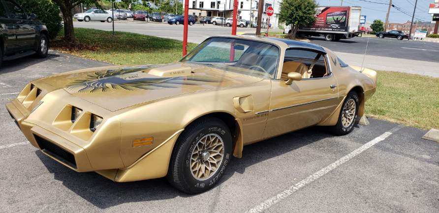 A gold Pontiac Firebird Trans Am with a black 