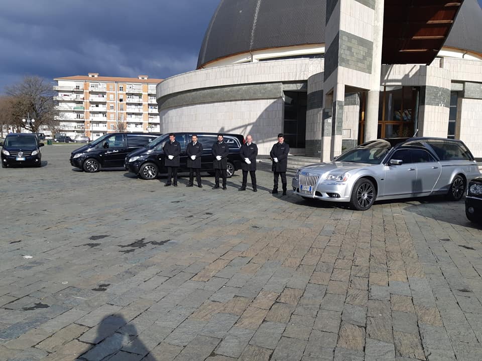 Gli agenti di polizia sono in piedi accanto alle auto parcheggiate davanti a un grande edificio moderno in una piazza