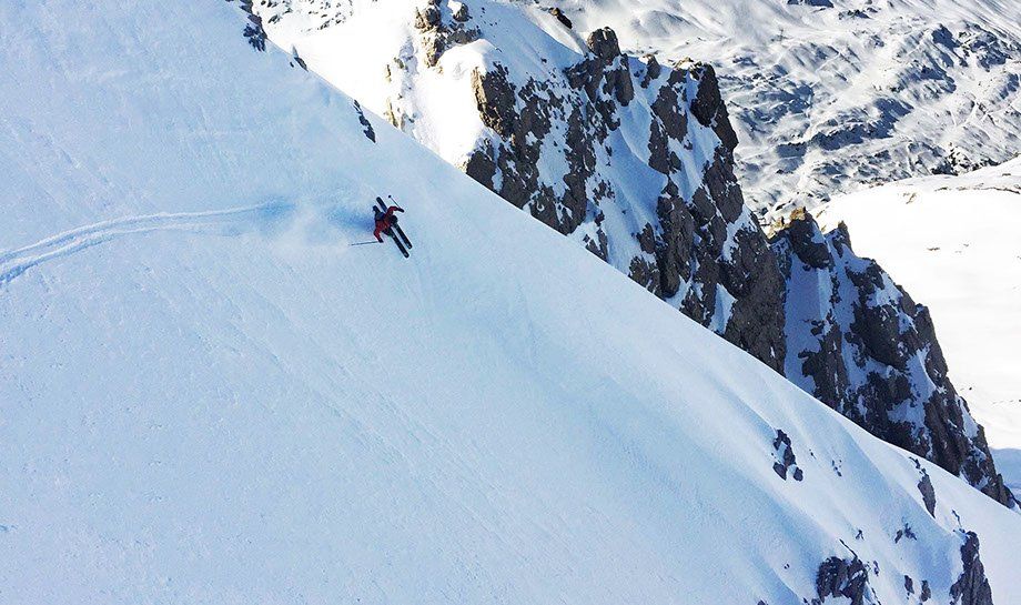 Schnee auf den Bergen mit Skifahrere ausserhalb der Piste