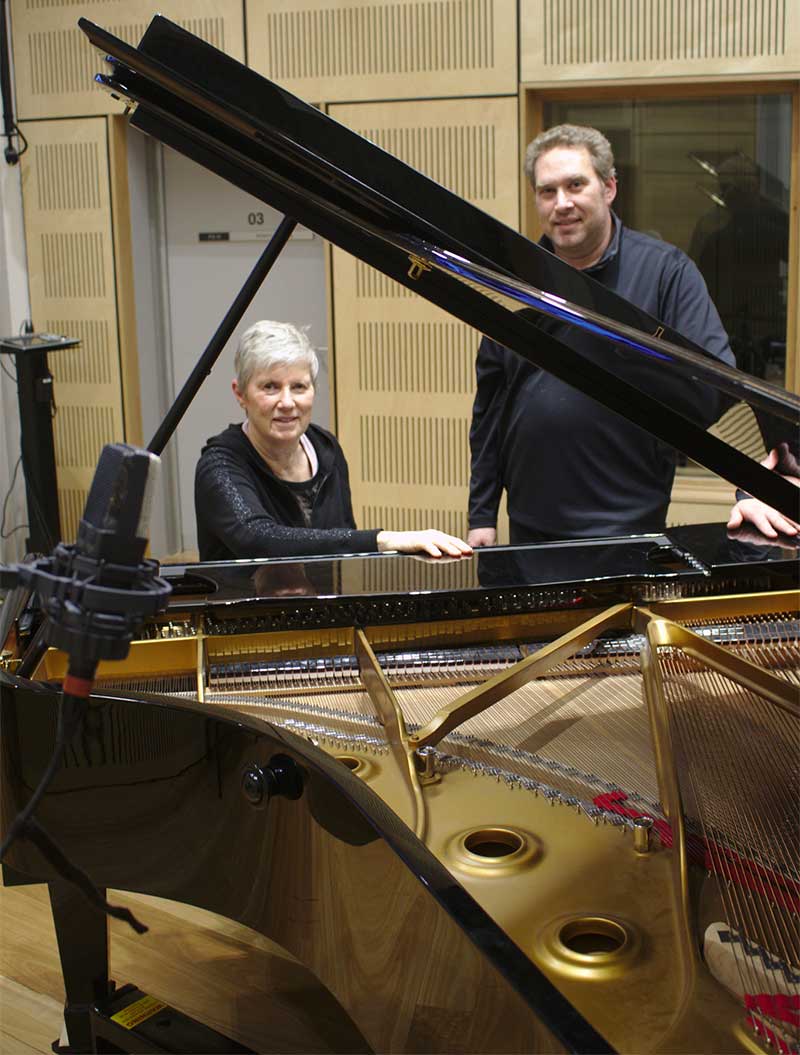 couple standing next to a piano