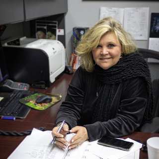 blonde woman sitting at desk for truck driving school