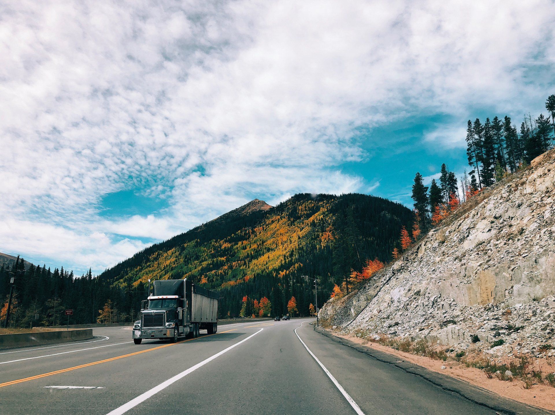 Enjoy amazing views as a truck driver with amazing pay! Big Truck going down the interstate with beautiful scenery in the background