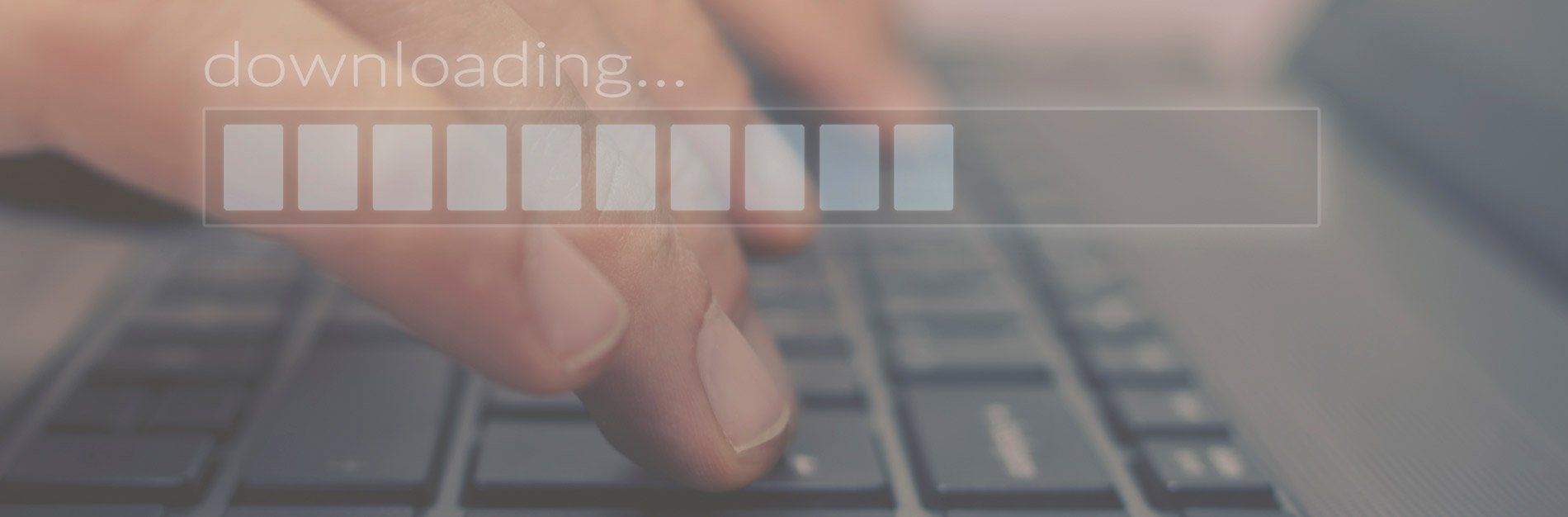 A person typing on a laptop with a loading bar overlay, indicating a download is in progress.